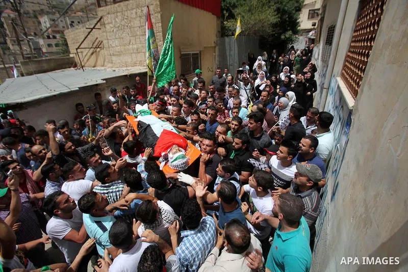 Mourners carry the body of Palestinian Jamal Dwikat, who died from wounds he sustained after he was shot during clashes with the Israeli army on Friday, during his funeral in the West Bank village of Balata Albalad near...