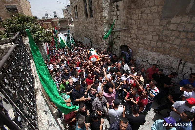 Mourners carry the body of Palestinian Jamal Dwikat, who died from wounds he sustained after he was shot during clashes with the Israeli army on Friday, during his funeral in the West Bank village of Balata Albalad near...