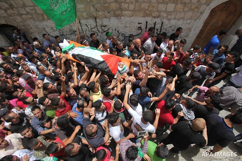 Mourners carry the body of Palestinian Jamal Dwikat, who died from wounds he sustained after he was shot during clashes with the Israeli army on Friday, during his funeral in the West Bank village of Balata Albalad near...