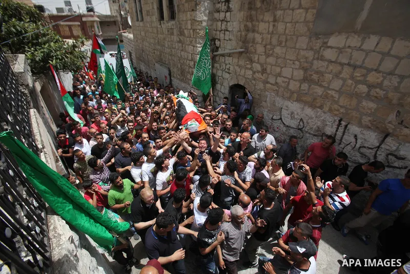 Mourners carry the body of Palestinian Jamal Dwikat, who died from wounds he sustained after he was shot during clashes with the Israeli army on Friday, during his funeral in the West Bank village of Balata Albalad near...