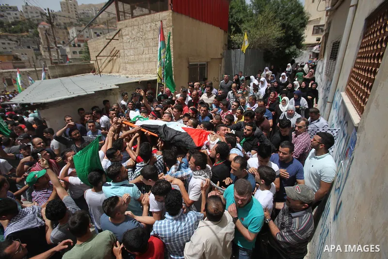 Mourners carry the body of Palestinian Jamal Dwikat, who died from wounds he sustained after he was shot during clashes with the Israeli army on Friday, during his funeral in the West Bank village of Balata Albalad near...