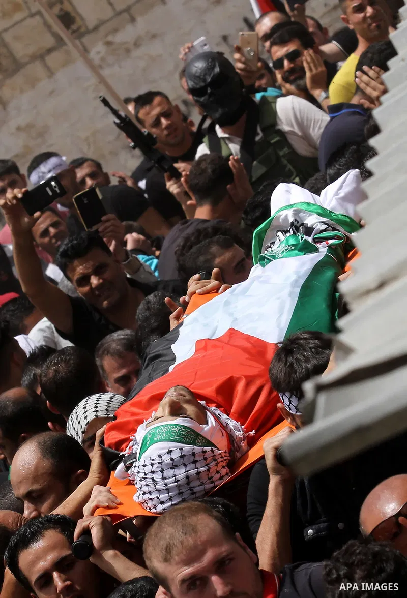 Mourners carry the body of Palestinian Jamal Dwikat, who died from wounds he sustained after he was shot during clashes with the Israeli army on Friday, during his funeral in the West Bank village of Balata Albalad near...