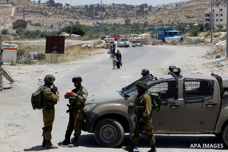 Israeli soldiers stand guard at the entrance of Yatta near the West Bank city of Hebron June 9, 2016. The Israeli army entered the village in search for clues leading to an attack the previous night in the Israeli city o...