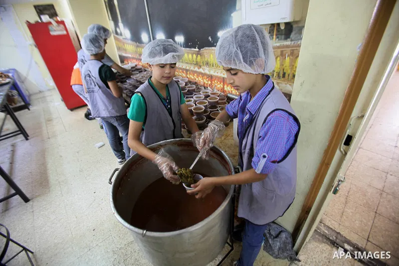 Palestinian children prepare food for the poor Palestinians from an Islamic charity "Tekkia" in the West Bank city of Nablus on the holy month of Ramadan on June 09, 2016. Ramadan is sacred to Muslims because it is durin...