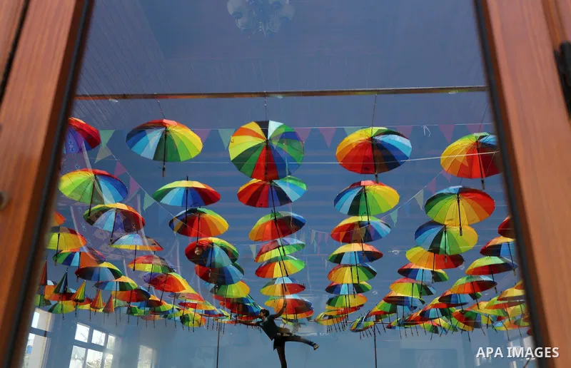 A Palestinian worker of a beachside café shop decorates its terrace with hanging colourful umbrellas as part of decorations for the Muslim holy fasting month of Ramadan in Gaza City, on June 9, 2016. Ramadan is sacred to...