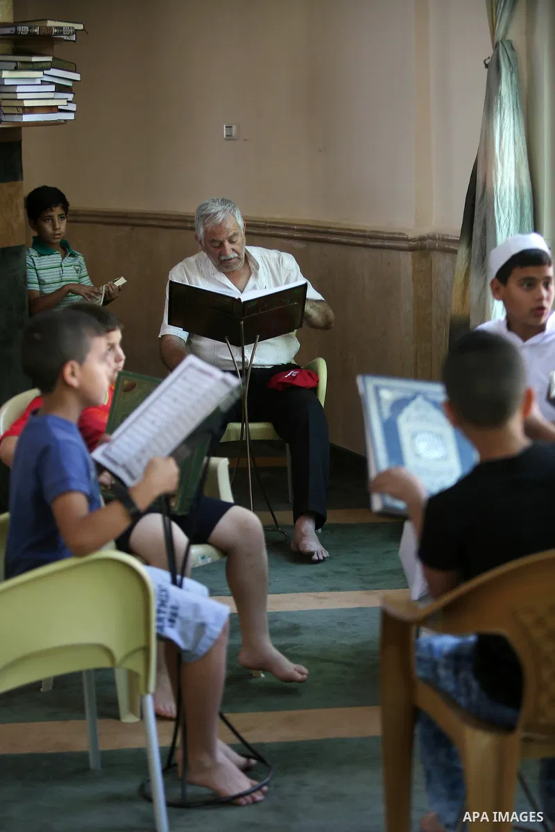 Palestinian Muslim children read the holy Koran, Islam's holy book at Tameem al-Dari mosque on the holy month of Ramadan in the West bank city of Ramallah, on June 09, 2016. Ramadan is sacred to Muslims because it is dur...