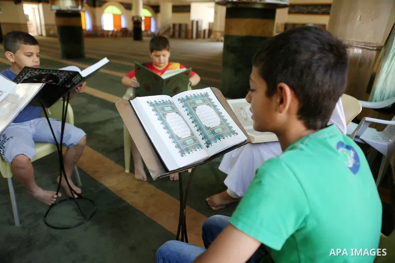 Palestinian Muslim children read the holy Koran, Islam's holy book at Tameem al-Dari mosque on the holy month of Ramadan in the West bank city of Ramallah, on June 09, 2016. Ramadan is sacred to Muslims because it is dur...