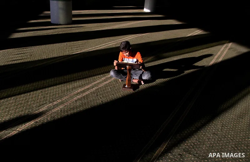 A Palestinian boy reads the holy Koran, Islam's holy book, at a Mosque during the Muslim holy fasting month of Ramadan in Rafah in the southern Gaza strip, on June 9, 2016. Photo by Abed Rahim Khatib