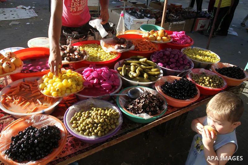 A Palestinian man sells pickles at a market during the Muslim holy fasting month of Ramadan in Rafah in the southern Gaza strip, on June 9, 2016. Photo by Abed Rahim Khatib