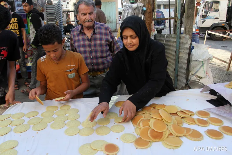 A Palestinian woman prepares traditional pancakes known as ''Qatayef at a market during the Muslim holy fasting month of Ramadan in Rafah in the southern Gaza strip, on June 9, 2016. Photo by Abed Rahim Khatib