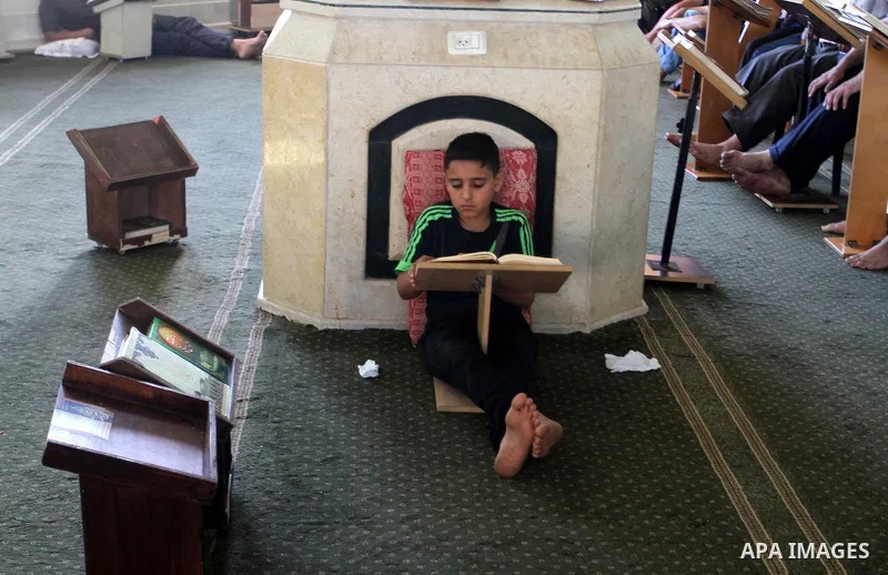 Palestinian Muslims read the holy Koran, Islam's holy book, at a Mosque during the Muslim holy fasting month of Ramadan in Rafah in the southern Gaza strip, on June 9, 2016. Photo by Abed Rahim Khatib