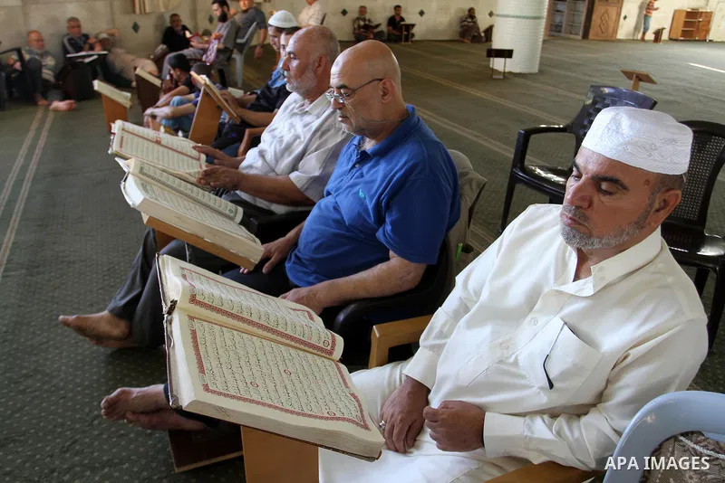 Palestinian Muslims read the holy Koran, Islam's holy book, at a Mosque during the Muslim holy fasting month of Ramadan in Rafah in the southern Gaza strip, on June 9, 2016. Photo by Abed Rahim Khatib