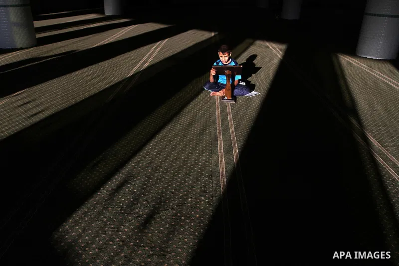 A Palestinian boy reads the holy Koran, Islam's holy book, at a Mosque during the Muslim holy fasting month of Ramadan in Rafah in the southern Gaza strip, on June 9, 2016. Photo by Abed Rahim Khatib