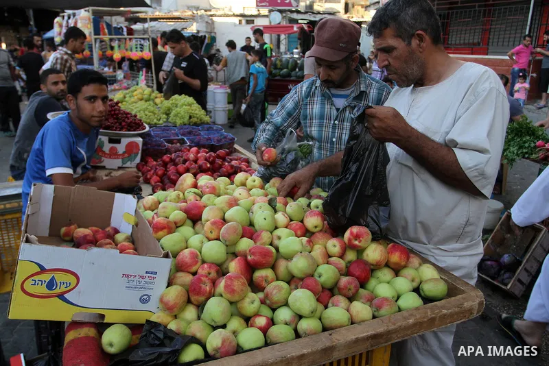 Palestinians shop at a market during the Muslim holy fasting month of Ramadan in Rafah in the southern Gaza strip, on June 9, 2016. Photo by Abed Rahim Khatib