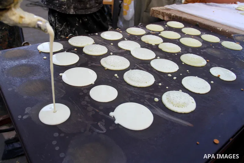 A Palestinian man prepares traditional pancakes known as ''Qatayef at a market during the Muslim holy fasting month of Ramadan in Rafah in the southern Gaza strip, on June 9, 2016. Photo by Abed Rahim Khatib