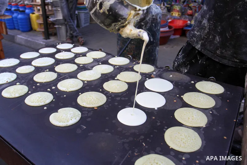 A Palestinian man prepares traditional pancakes known as ''Qatayef at a market during the Muslim holy fasting month of Ramadan in Rafah in the southern Gaza strip, on June 9, 2016. Photo by Abed Rahim Khatib