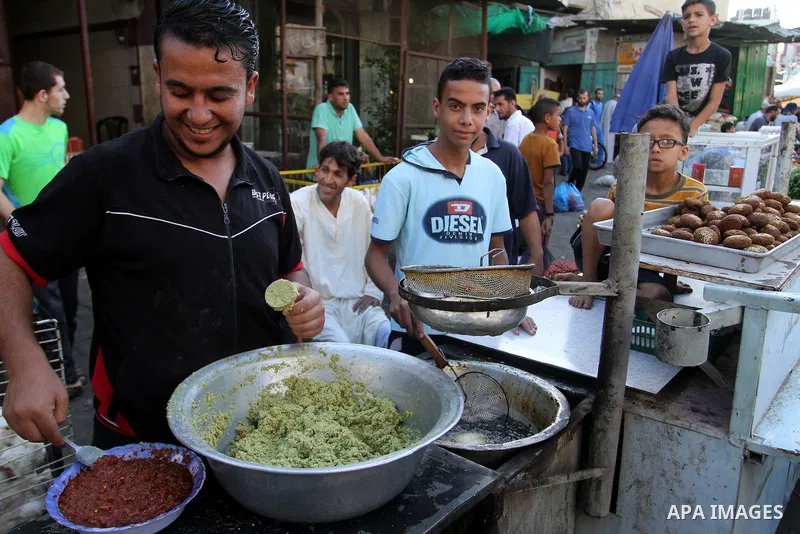 Palestinians shop at a market during the Muslim holy fasting month of Ramadan in Rafah in the southern Gaza strip, on June 9, 2016. Photo by Abed Rahim Khatib