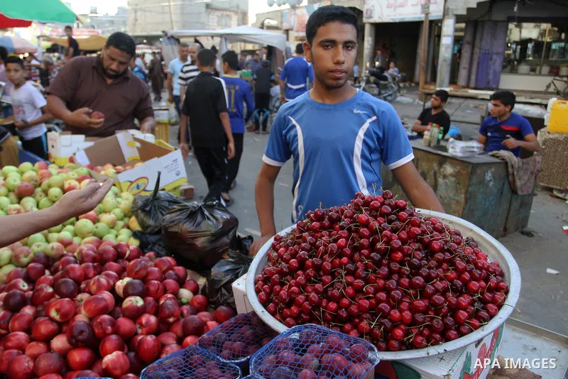 Palestinians shop at a market during the Muslim holy fasting month of Ramadan in Rafah in the southern Gaza strip, on June 9, 2016. Photo by Abed Rahim Khatib