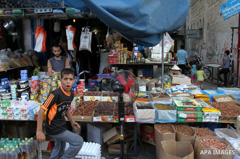 Palestinians shop at a market during the Muslim holy fasting month of Ramadan in Rafah in the southern Gaza strip, on June 9, 2016. Photo by Abed Rahim Khatib