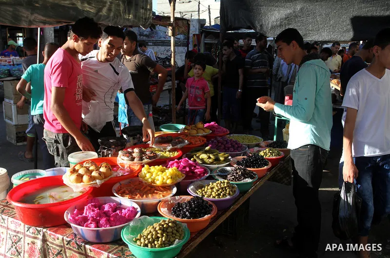 A Palestinian man sells pickles at a market during the Muslim holy fasting month of Ramadan in Rafah in the southern Gaza strip, on June 9, 2016. Photo by Abed Rahim Khatib