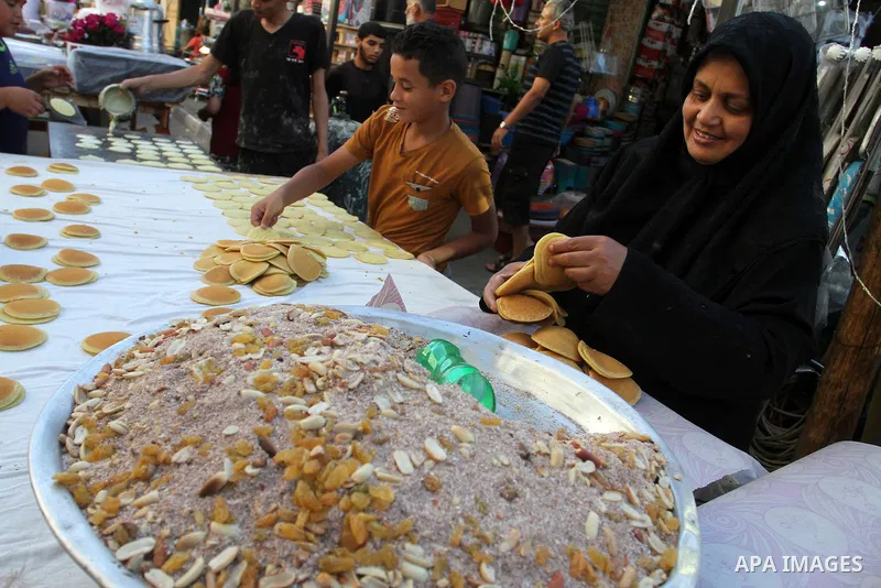 A Palestinian woman prepares traditional pancakes known as ''Qatayef at a market during the Muslim holy fasting month of Ramadan in Rafah in the southern Gaza strip, on June 9, 2016. Photo by Abed Rahim Khatib