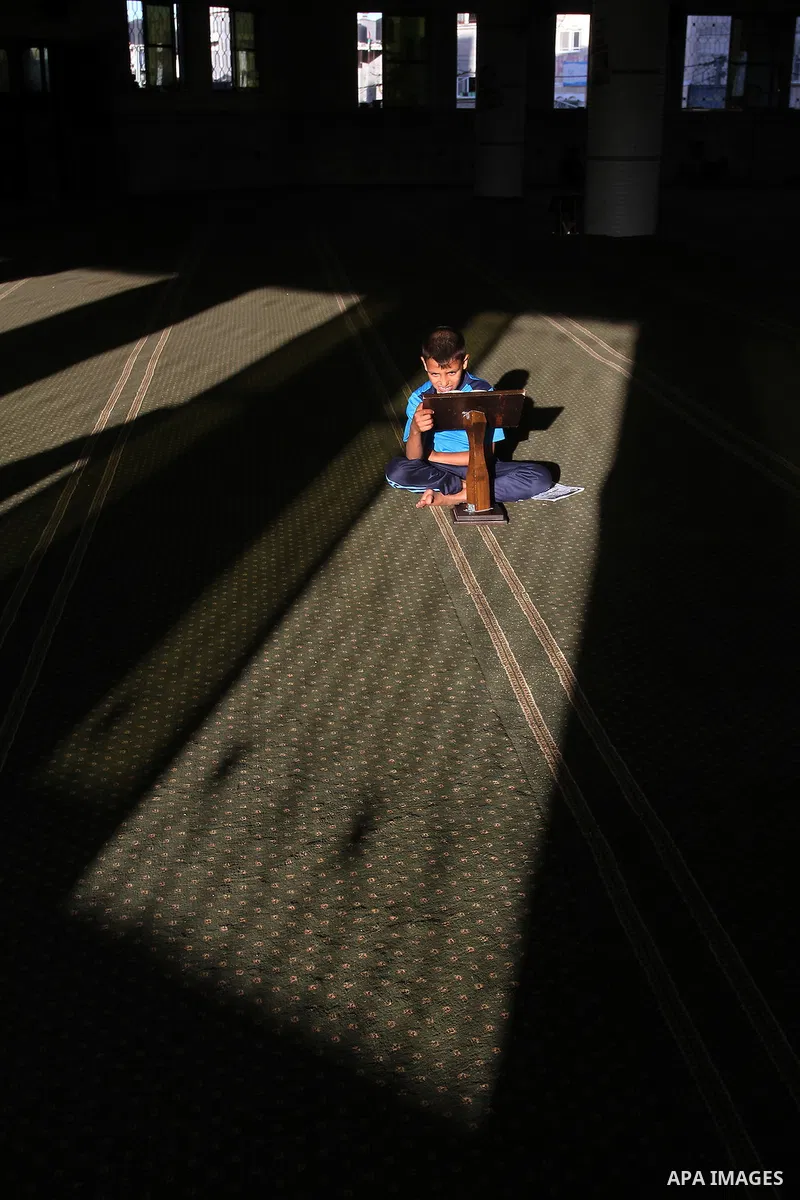 A Palestinian boy reads the holy Koran, Islam's holy book, at a Mosque during the Muslim holy fasting month of Ramadan in Rafah in the southern Gaza strip, on June 9, 2016. Photo by Abed Rahim Khatib