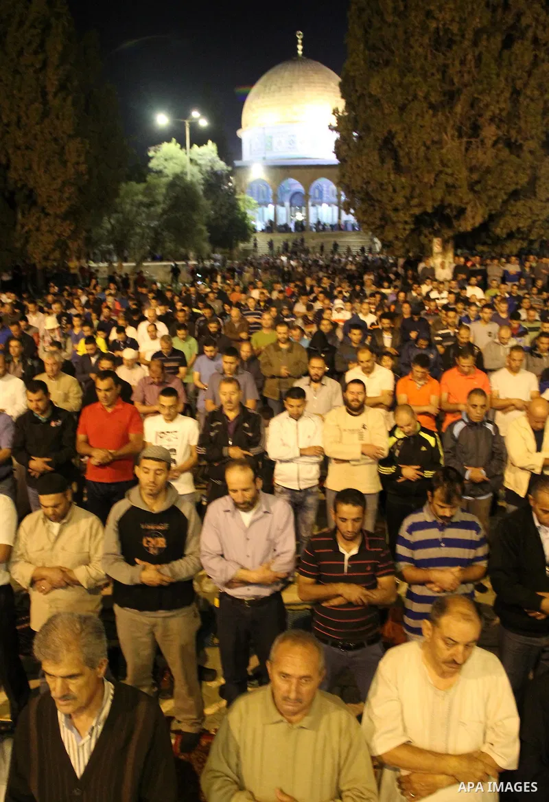 Palestinian Muslim worshipers perform "Taraweeh", nightly prayer of the month of Ramadan, in front of the Dome of the Rock mosque, in Jerusalem's old city on June 9, 2016. Ramadan is sacred to Muslims because it is durin...