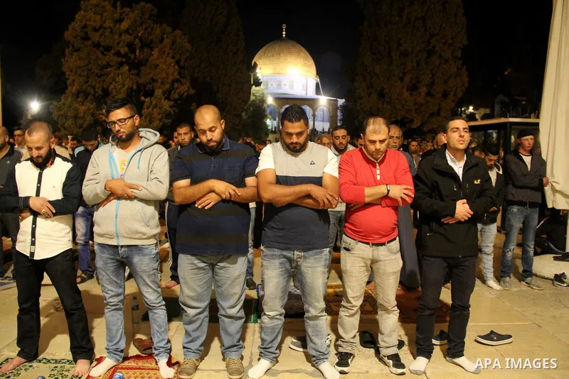 Palestinian Muslim worshipers perform "Taraweeh", nightly prayer of the month of Ramadan, in front of the Dome of the Rock mosque, in Jerusalem's old city on June 9, 2016. Ramadan is sacred to Muslims because it is durin...
