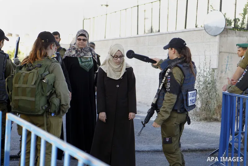 Palestinians walk to the Israeli checkpoint between the West Bank town of Bethlehem and Jerusalem, as Palestinians wait to cross to Jerusalem to attend the first Friday noon prayers of the holy Muslim fasting month of Ra...