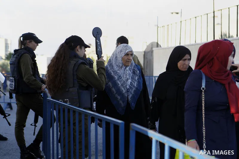 Israeli border police check the identity card of a Palestinian at an Israeli checkpoint as he makes his way to attend the first Friday prayer of the holy fasting month of Ramadan in Jerusalem's al-Aqsa mosque, in the Wes...