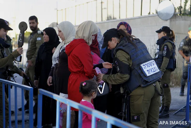 Israeli border police check the identity card of a Palestinian at an Israeli checkpoint as he makes his way to attend the first Friday prayer of the holy fasting month of Ramadan in Jerusalem's al-Aqsa mosque, in the Wes...