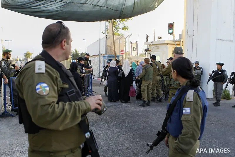Israeli border police check the identity card of a Palestinian at an Israeli checkpoint as he makes his way to attend the first Friday prayer of the holy fasting month of Ramadan in Jerusalem's al-Aqsa mosque, in the Wes...