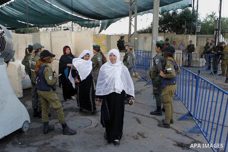 Israeli border police check the identity card of a Palestinian at an Israeli checkpoint as he makes his way to attend the first Friday prayer of the holy fasting month of Ramadan in Jerusalem's al-Aqsa mosque, in the Wes...