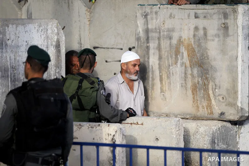 Israeli border police check the identity card of a Palestinian at an Israeli checkpoint as he makes his way to attend the first Friday prayer of the holy fasting month of Ramadan in Jerusalem's al-Aqsa mosque, in the Wes...
