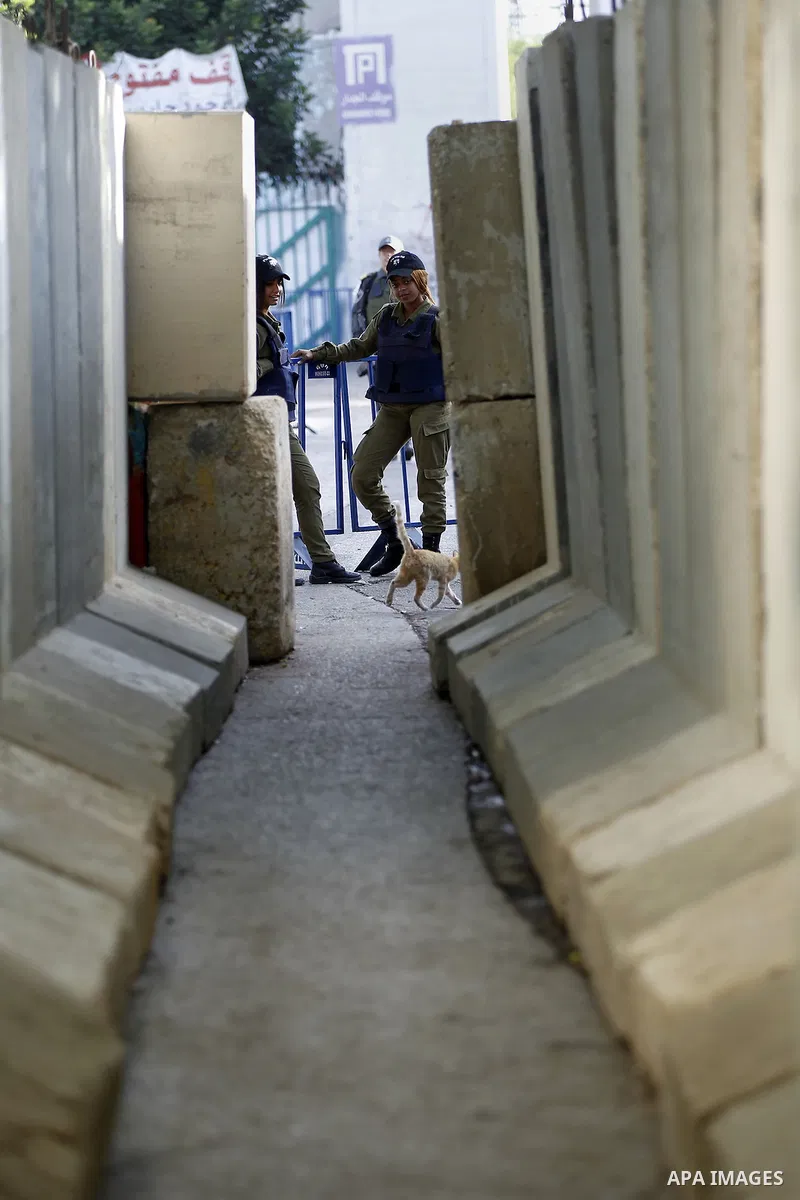 Palestinians walk to the Israeli checkpoint between the West Bank town of Bethlehem and Jerusalem, as Palestinians wait to cross to Jerusalem to attend the first Friday noon prayers of the holy Muslim fasting month of Ra...