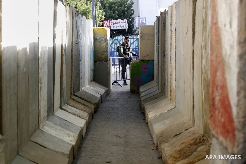 Palestinians walk to the Israeli checkpoint between the West Bank town of Bethlehem and Jerusalem, as Palestinians wait to cross to Jerusalem to attend the first Friday noon prayers of the holy Muslim fasting month of Ra...