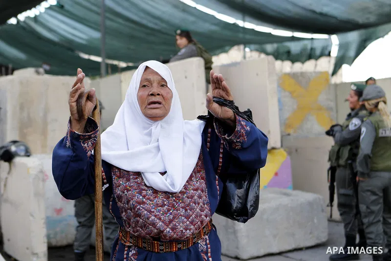 Palestinians walk to the Israeli checkpoint between the West Bank town of Bethlehem and Jerusalem, as Palestinians wait to cross to Jerusalem to attend the first Friday noon prayers of the holy Muslim fasting month of Ra...