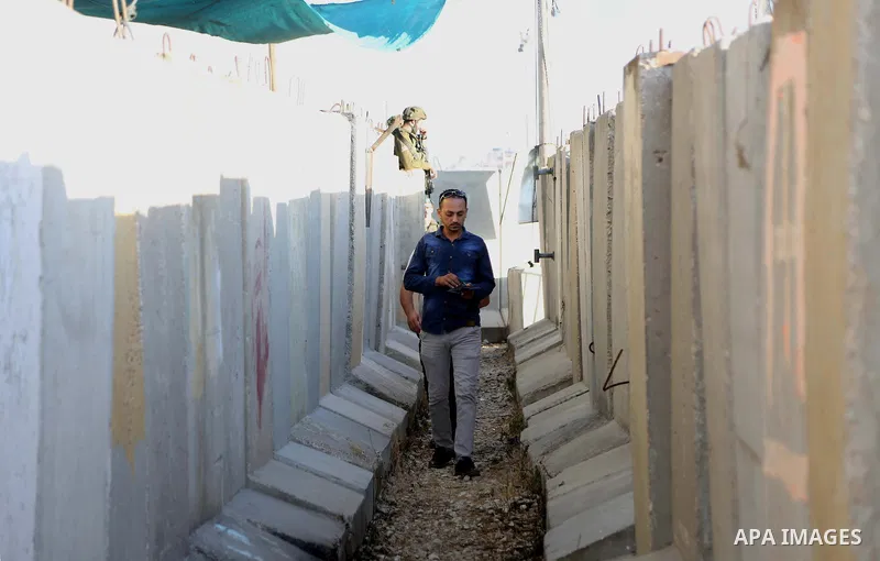 A Palestinian man walks towards the Qalandia checkpoint, a main crossing point between the West Bank city of Ramallah and Jerusalem on June 10, 2016, as they head to Jerusalem's Al-Aqsa mosque for the first Friday prayer...