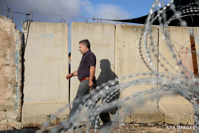 A Palestinian man walks towards the Qalandia checkpoint, a main crossing point between the West Bank city of Ramallah and Jerusalem on June 10, 2016, as they head to Jerusalem's Al-Aqsa mosque for the first Friday prayer...