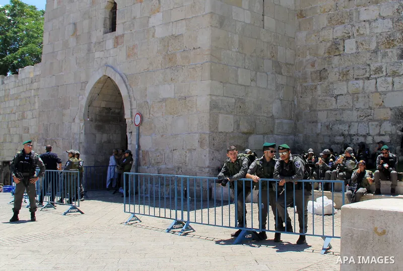 Israeli border police stand guard while Palestinians pray in front of the Dome of the Rock at Jerusalem's Al-Asqa mosque compound during the first Friday prayers of the holy Muslim fasting month of Ramadan on June 10, 20...