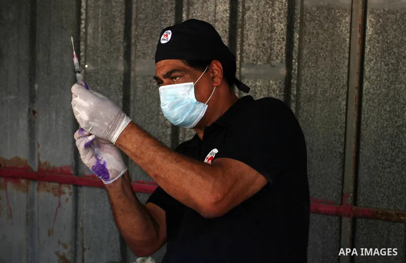 Veterinarian Amir Khalil from the international animal protecting organization Four Paws checks a monkey from a zoo in the southern Gaza Strip city of Khan Younis, June 10, 2016. Photo by Abed Rahim Khatib