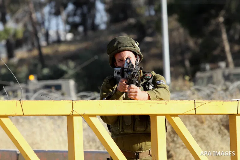 A member of Israeli security forces stands guard at a checkpoint near the West Bank city of Nablus, June 10, 2016, after a Palestinian man attempted a stabbing attack. Palestinian was shot and wounded, army said. Photo b...