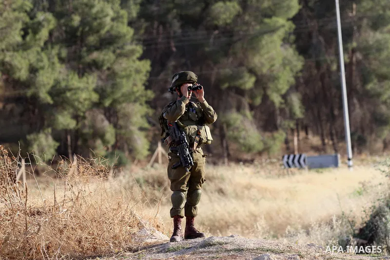 A member of Israeli security forces uses binoculars at a checkpoint near the West Bank city of Nablus, June 10, 2016, after a Palestinian man attempted a stabbing attack. Palestinian was shot and wounded, army said. Phot...
