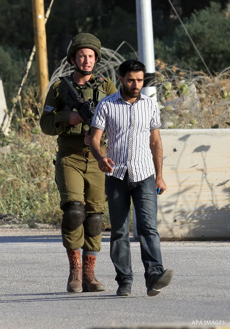 Israeli security forces arrest a Palestinian at a checkpoint near the West Bank city of Nablus, June 10, 2016, after a Palestinian man attempted a stabbing attack. Palestinian was shot and wounded, army said. Photo by Ne...