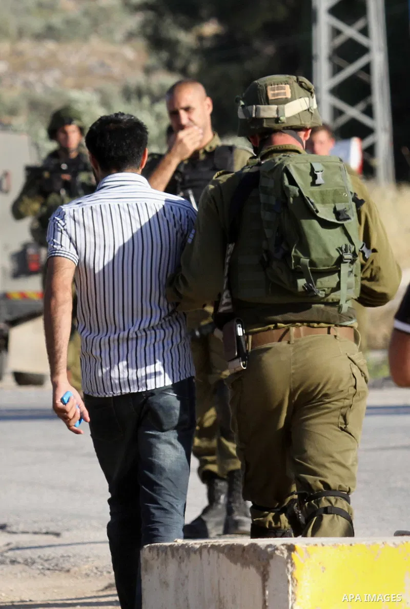 Israeli security forces arrest a Palestinian at a checkpoint near the West Bank city of Nablus, June 10, 2016, after a Palestinian man attempted a stabbing attack. Palestinian was shot and wounded, army said. Photo by Ne...