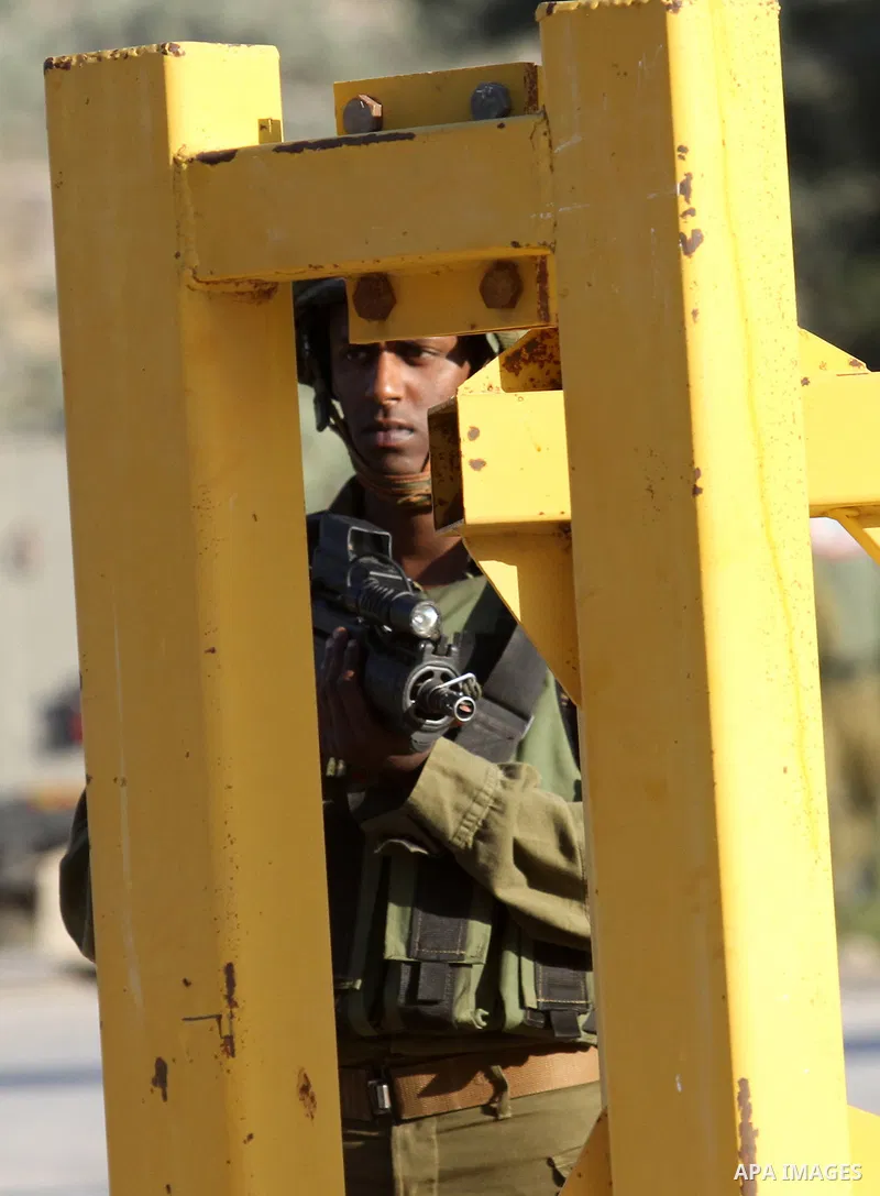 A member of Israeli security forces stands guard at a checkpoint near the West Bank city of Nablus, June 10, 2016, after a Palestinian man attempted a stabbing attack. Palestinian was shot and wounded, army said. Photo b...