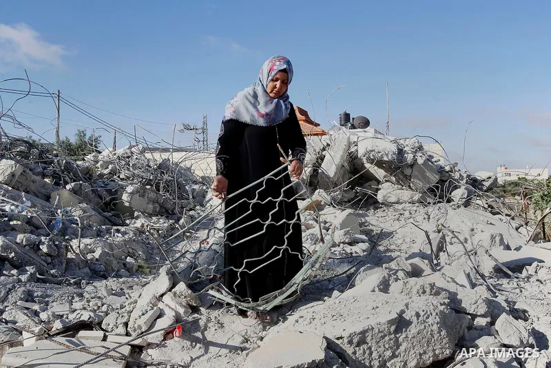 The mother of 15-year old Palestinian teenager Murad Idais who was accused of stabbing to death a 38-year old Israeli nurse in an attack in the Israeli Otniel settlement in January 2016 inspects the rubble of their house...