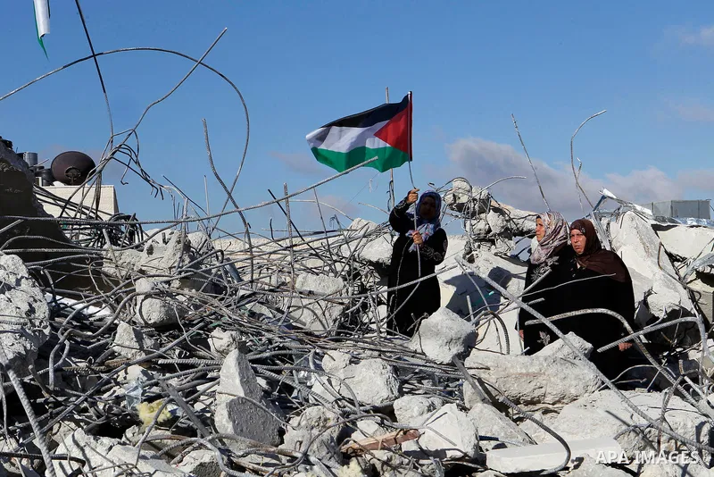 The mother of 15-year old Palestinian teenager Murad Idais who was accused of stabbing to death a 38-year old Israeli nurse in an attack in the Israeli Otniel settlement in January 2016 holds a Palestinian flag as she st...