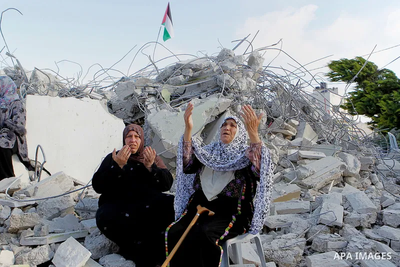 The grandmother of 15-year old Palestinian teenager Murad Idais who was accused of stabbing to death a 38-year old Israeli nurse in an attack in the Israeli Otniel settlement in January 2016 reacts on the rubble of his f...