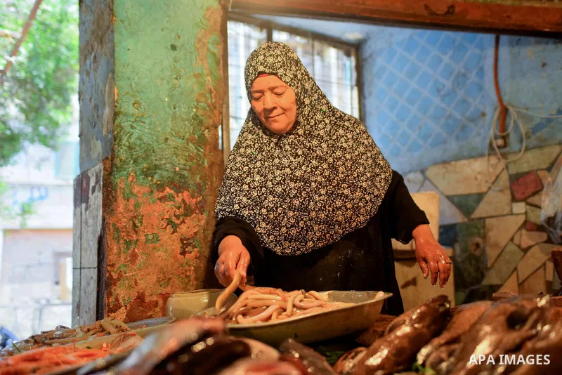 An Egyptian woman displays fishes at her shop on the holy month of Ramadan at a fishes market at the Imbaba area in Cairo, Egypt, on June 11, 2016. Ramadan is sacred to Muslims because it is during that month that tradit...